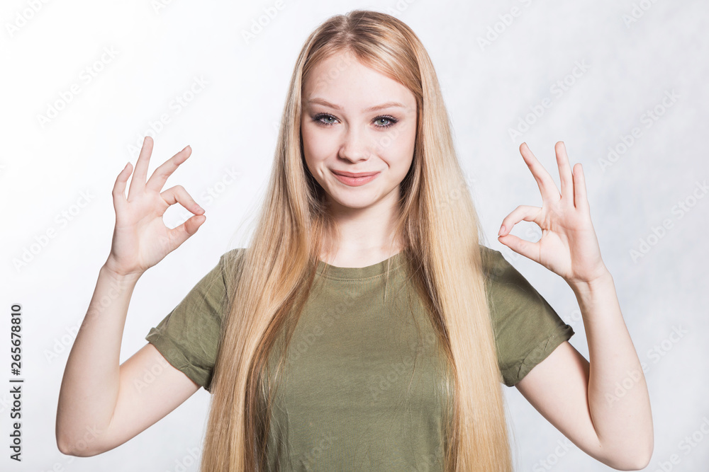 Young beautiful smiling woman shows ok sign. Body language concept. Young beautiful smiling woman shows ok sign. Body language concept.