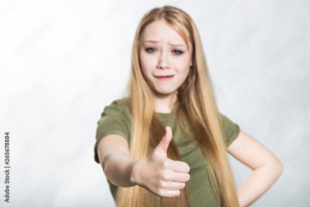 Young beautiful woman shows thumbs up sign. Body language concept. Young beautiful woman shows thumbs up sign. Body language concept.