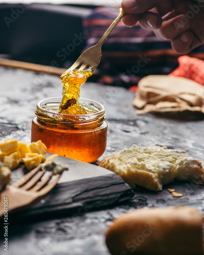 Fruit jams and marmalades with various cheeses on a plate. Breakfast with coffee and cheese