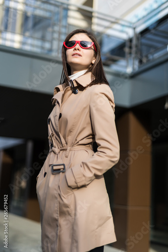 Young stylish woman walking on the street wearing stylish bright coat and skirt. © dianagrytsku