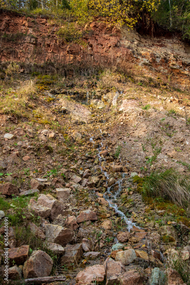 sandstone cliffs with waterfall near river sandstone cliffs with waterfall near river