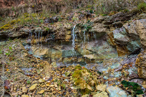 sandstone cliffs with waterfall near river