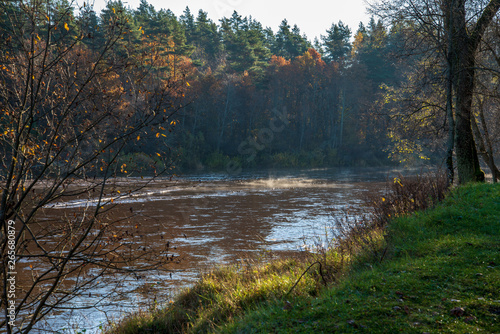 morning mist on calm water on countryside river in autumn