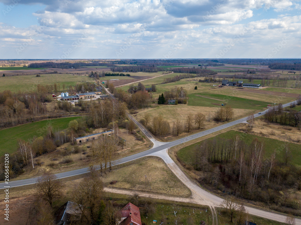 aerial view of country roads and small village with houses and lake