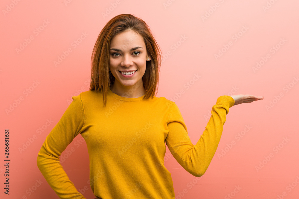 Young pretty young woman showing a copy space on a palm and holding another hand on waist. Young pretty young woman showing a copy space on a palm and holding another hand on waist.