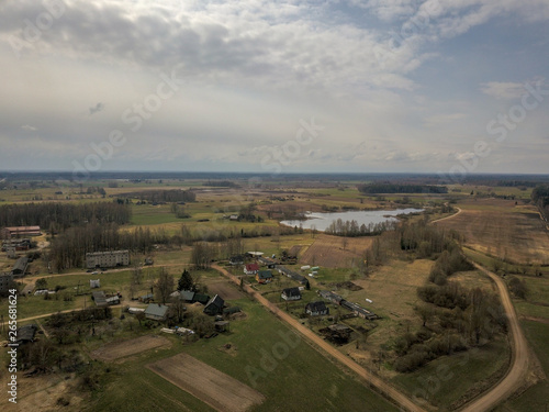 aerial view of country roads and small village with houses and lake