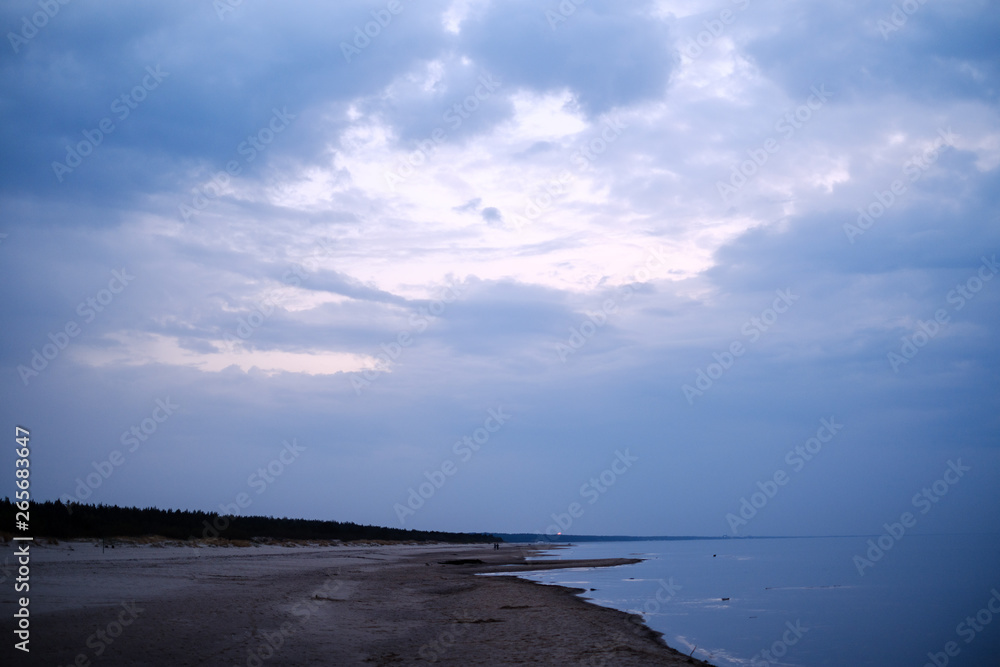 Obraz premium calm sea beach on the shore of Baltic sea with blue clouds and low tide