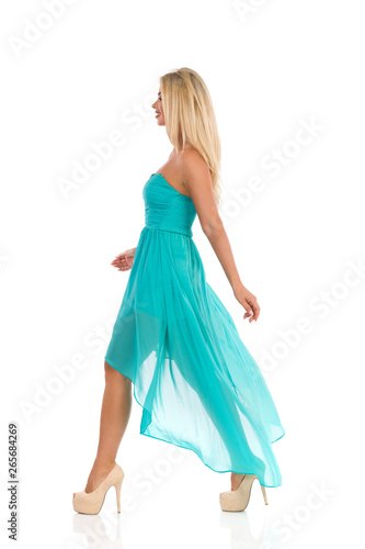 Fashion Model In Turquoise Dress Is Walking And Looking Away © studioloco