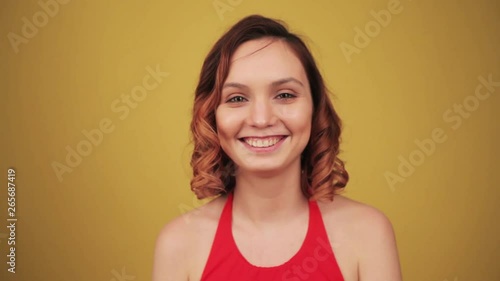 Beautiful girl smiling on yellow background photo