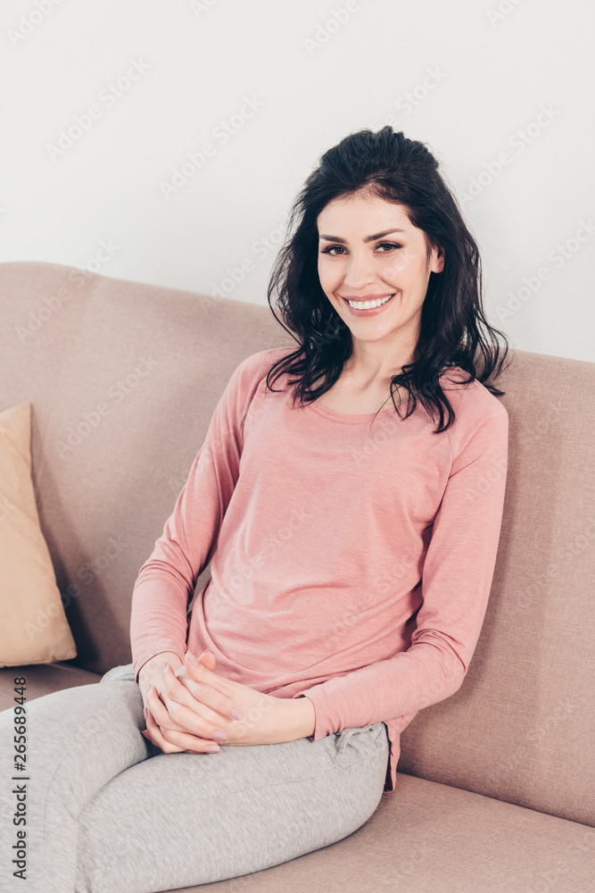 beautiful happy woman sitting on couch and looking at camera at home beautiful happy woman sitting on couch and looking at camera at home