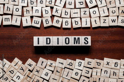 Idioms word concept on cubes photo