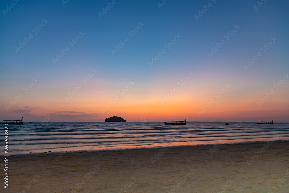 Fototapeta premium Beautiful sunset with the silhouette of a island and boat in Otres, Cambodia.