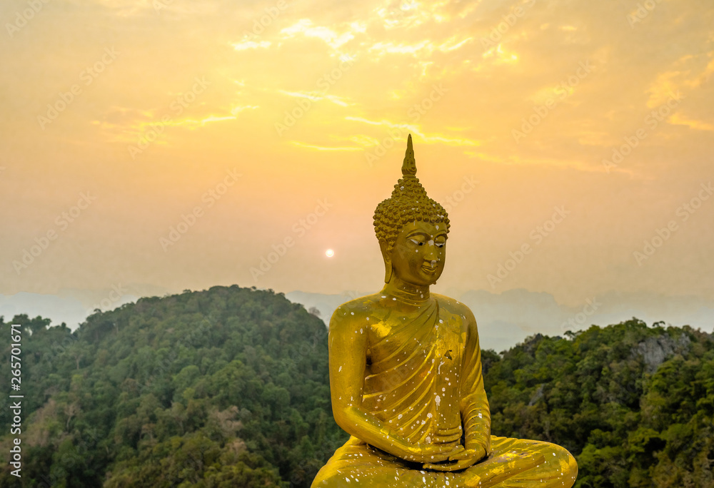 Obraz premium Golden Buddha statue on the top of the Wat Tham Sua or Tiger Cave Temple in Krabi province. Sunset sky
