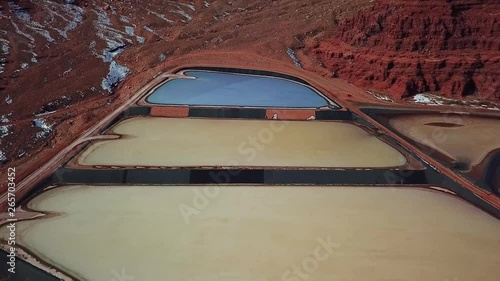 Aerial, reverse, drone shot, tilting up above colorful tailing ponds for mineral waste in rural Utah mines, United States of America photo