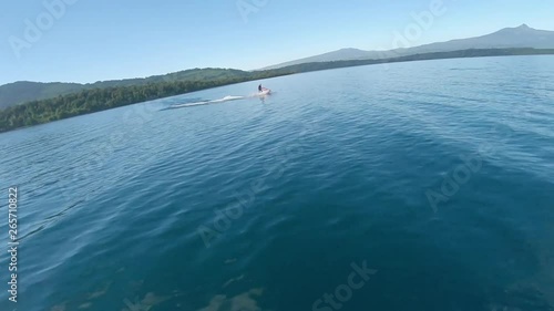 FPV Racing Drone Speeding Towards Jet Ski on Lake. photo