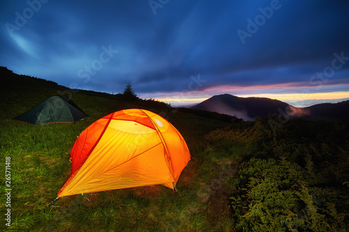 Yellow Illuminated Tent in the Beautirul Evening Mountains.