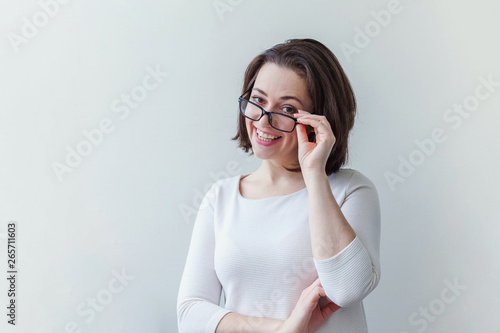 Beautiful happy girl smiling. Beauty simple portrait young smiling brunette woman in eyeglasses isolated on white background. Positive human emotion facial expression body language. Copy space