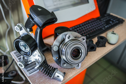 Papier peint Car parts on a table with a computer in the background with a shallow depth of f