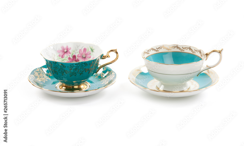 High resolution close-up of two beautiful antique tea cups with saucers isolated on a white background. High resolution close-up of two beautiful antique tea cups with saucers isolated on a white background.