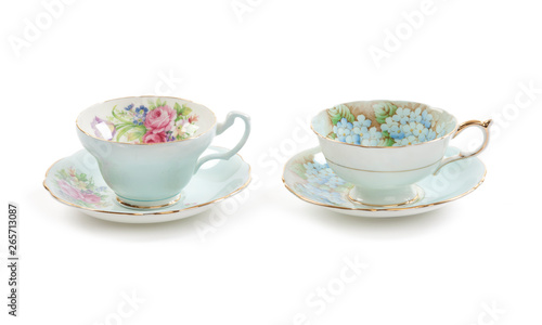 High resolution close-up of two beautiful antique tea cups with saucers isolated on a white background.