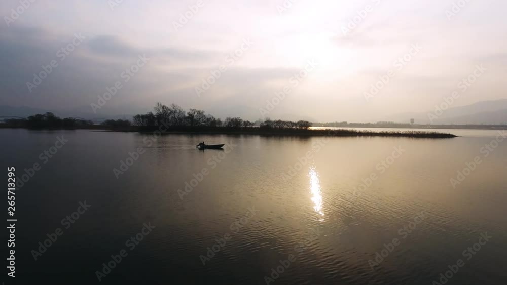 A man going out fishing boat silhouette in the sunrise, yangsuri, Korea A man going out fishing boat silhouette in the sunrise, yangsuri, Korea