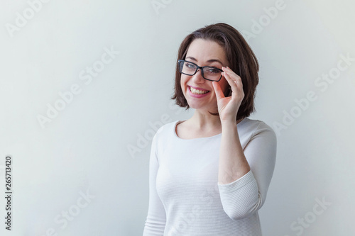 Beautiful happy girl smiling. Beauty simple portrait young smiling brunette woman in eyeglasses isolated on white background. Positive human emotion facial expression body language. Copy space