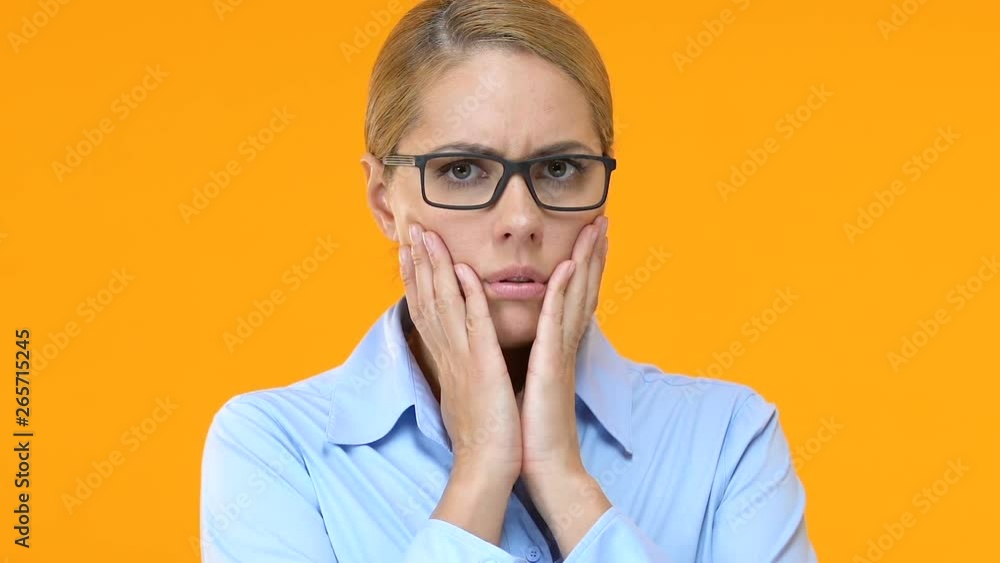 Beautiful business woman shocked by corporative gossips, yellow background Beautiful business woman shocked by corporative gossips, yellow background