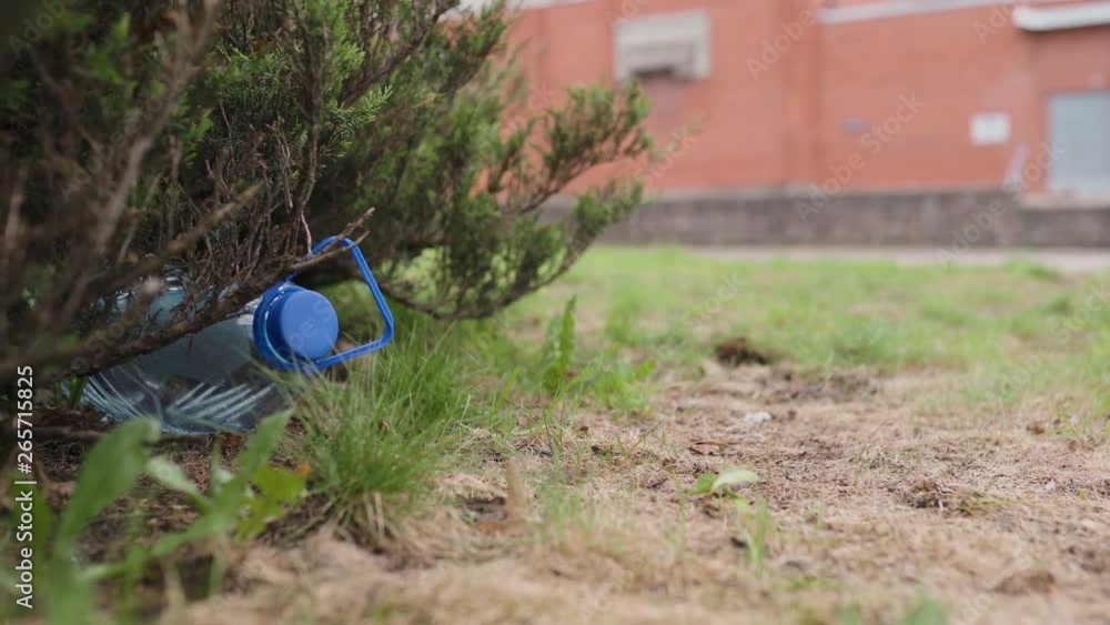 Blue big plastic bottle lying on the ground in tree in a park forest - Thrown out not recycled - Trash and pollution of the city and nature - Decayed rubbish Blue big plastic bottle lying on the ground in tree in a park forest - Thrown out not recycled - Trash and pollution of the city and nature - Decayed rubbish