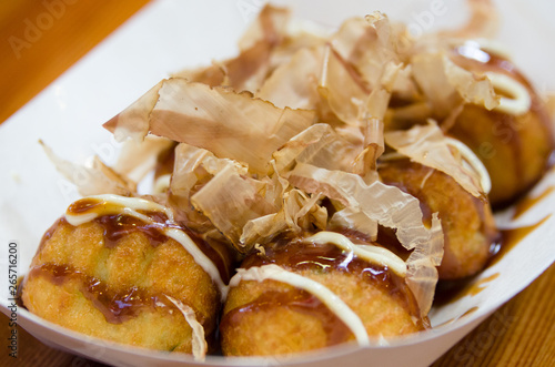 Closeup of Takoyaki takeout dish with shavings and sauce