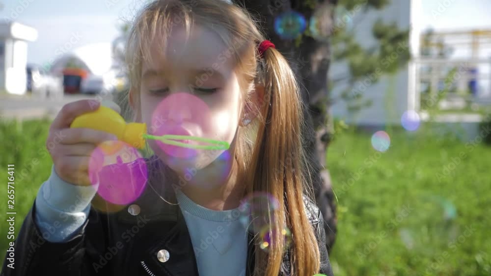 Little girl blowing soap bubbles in summer park. Slow mo video. Little girl blowing soap bubbles in summer park. Slow mo video.