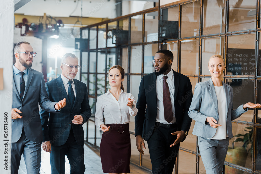 multicultural group of handsome businessmen and happy businesswomen walking in office multicultural group of handsome businessmen and happy businesswomen walking in office