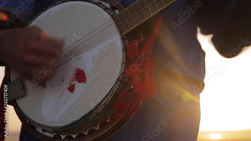 A moroccan musician playing the banjo in the beach of Essaouira on a beautiful sunset