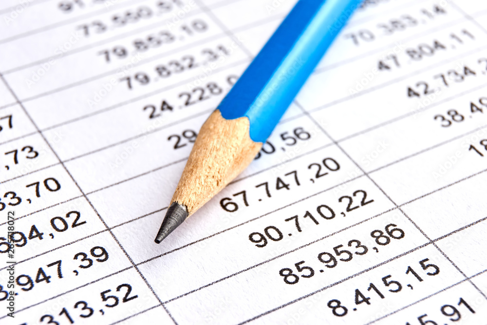 Blue pencil on a sheet of white paper with printed financial numerical data table with columns. Concept for accounting, budget, profit, tax and financial review. Image with selective focus    