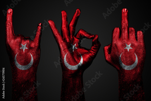 a set of three hands with a painted flag Turkey show middle finger, goat and Okay, a sign of aggression, protest and approval on a dark background. photo