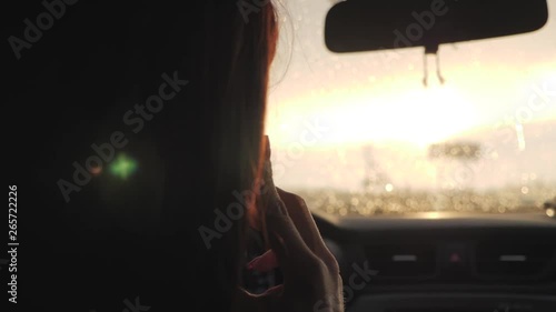 Wallpaper Mural Young woman looking to her smartphone while driving car, sun shines through front window. Girl driver use her cell phone in car. Torontodigital.ca