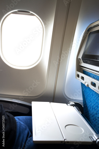 Airplane tray table opened on seat back by the window