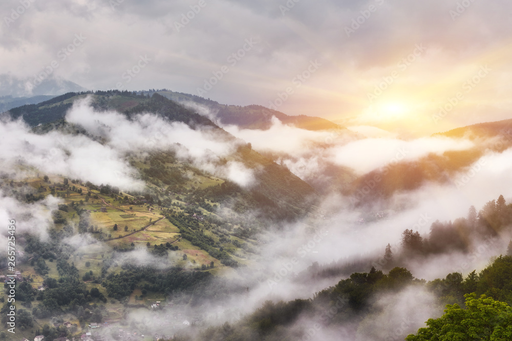 Western Europe mountainous terrain and alpine villages against the backdrop of the ridges bathe in the sea of fog after the rain