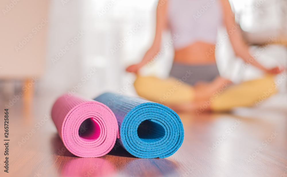 Yoga mats on wooden floor and blurred female body at the background. foto  de Stock | Adobe Stock