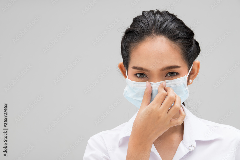 Young Asian University Student Woman in White Uniform cover face with hygiene mask protect from poor environment pm 2.5 industrial dust health, portrait half body studio lighting gray background