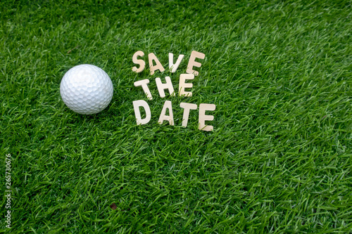 Golf ball with save the date word are on green grass