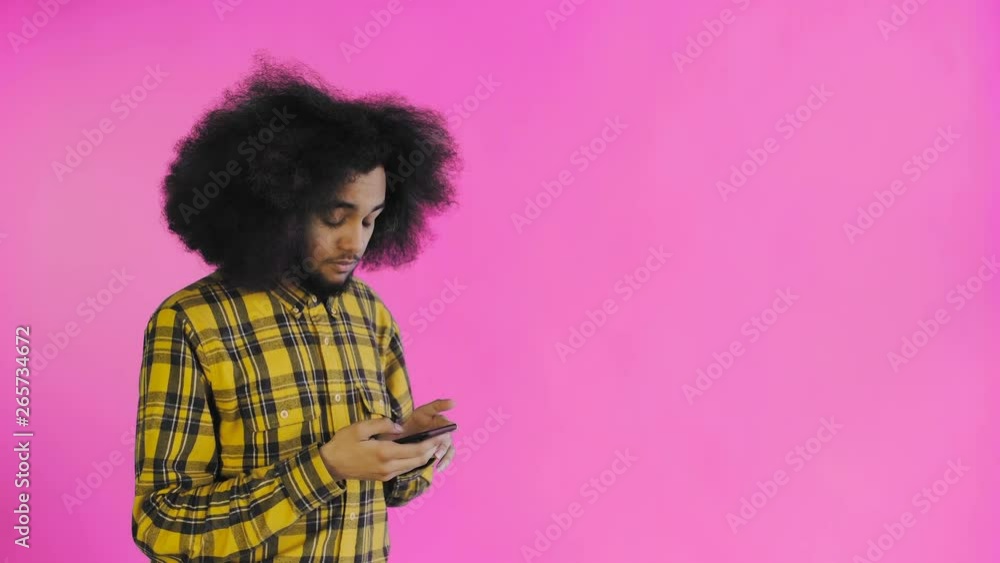 African American man received a new message on his phone on purple background. Concept of emotions African American man received a new message on his phone on purple background. Concept of emotions