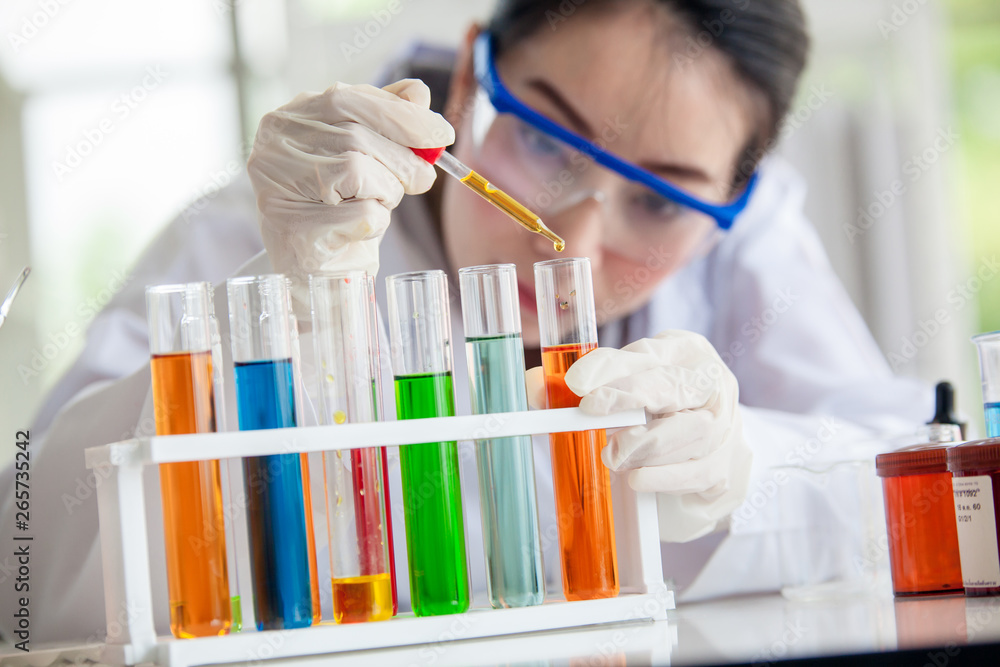 Closeup of a female scientist filling test tubes with pipette in laboratory science laboratory research and development concept Closeup of a female scientist filling test tubes with pipette in laboratory science laboratory research and development concept