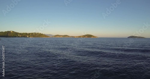 Steady Camera Shoot of Beautiful See and Boats that passing around and tourists on them. Filming in 4k in Skyathos, Greek island. Nice sunset with clear weather and no wind. Touristy and busy place. photo