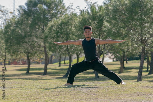 latin man doing yoga in the park