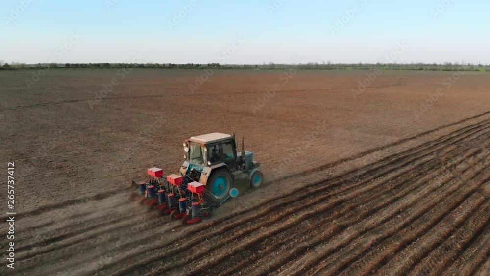Drone shoot of farmer on tractor with six row seeder sow corn for green fodder in field. Hard rural job Drone shoot of farmer on tractor with six row seeder sow corn for green fodder in field. Hard rural job