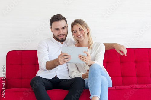 Couple using a tablet computer on Sofa in their living room
