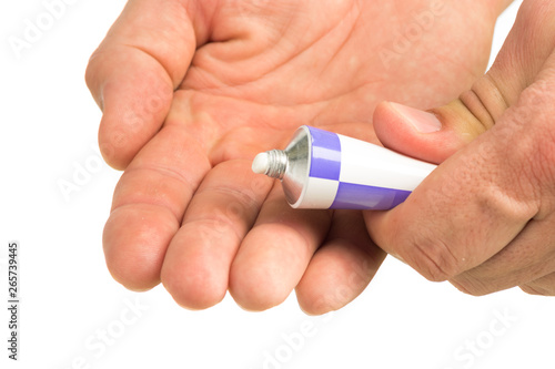 ointment for external use a little squeezed out of a tube on a white background, near the cover