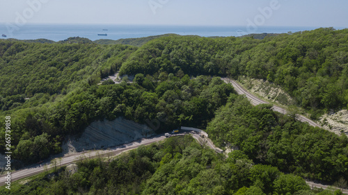 Aerial view over mountain road going through forest landscape, Winding road from high mountain pass.