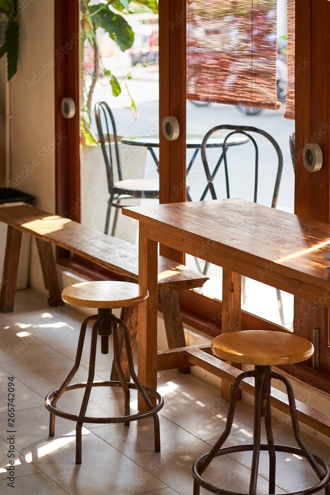 Sunshine to Wooden table and chairs beside the glass doors. 