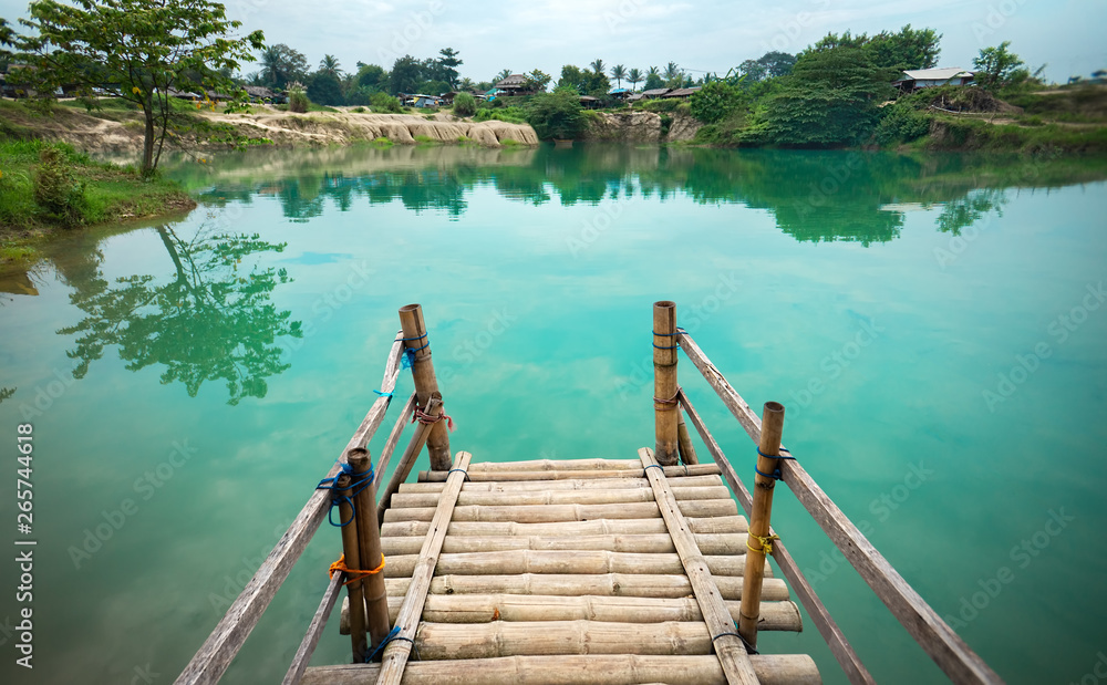 Wooden Pier on Green Blue Lagoon, Tropical Paradise. Traditional Bamboo Pier or Jetty on Lakeside. Concept of New Beginning of Exploration, Discovery or Exit Your Comfort Zone